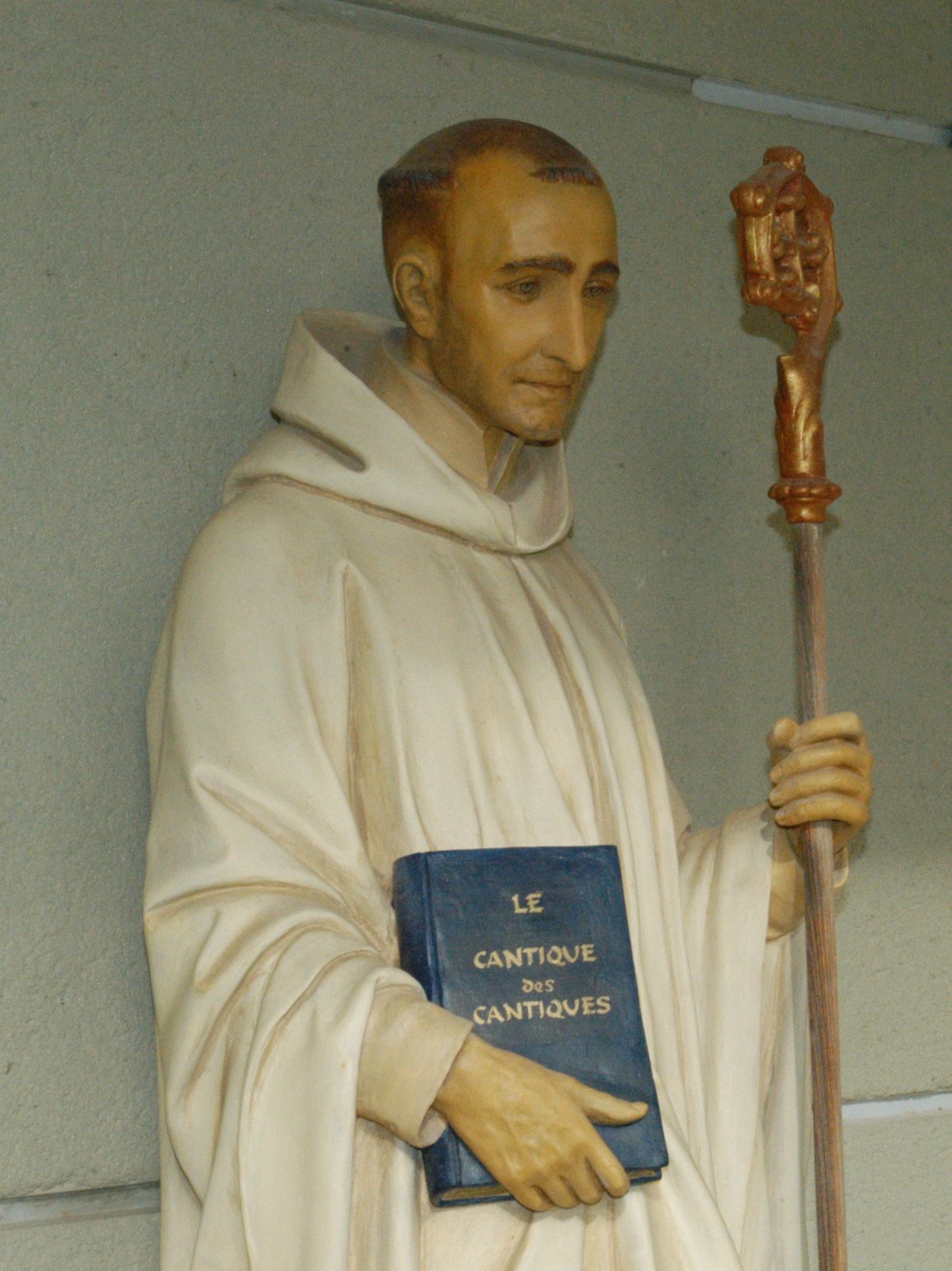 Statue de Saint Bernard dans le cloître de l'abbaye : en habit blanc avec la crosse et le livre du Cantique des cantiques